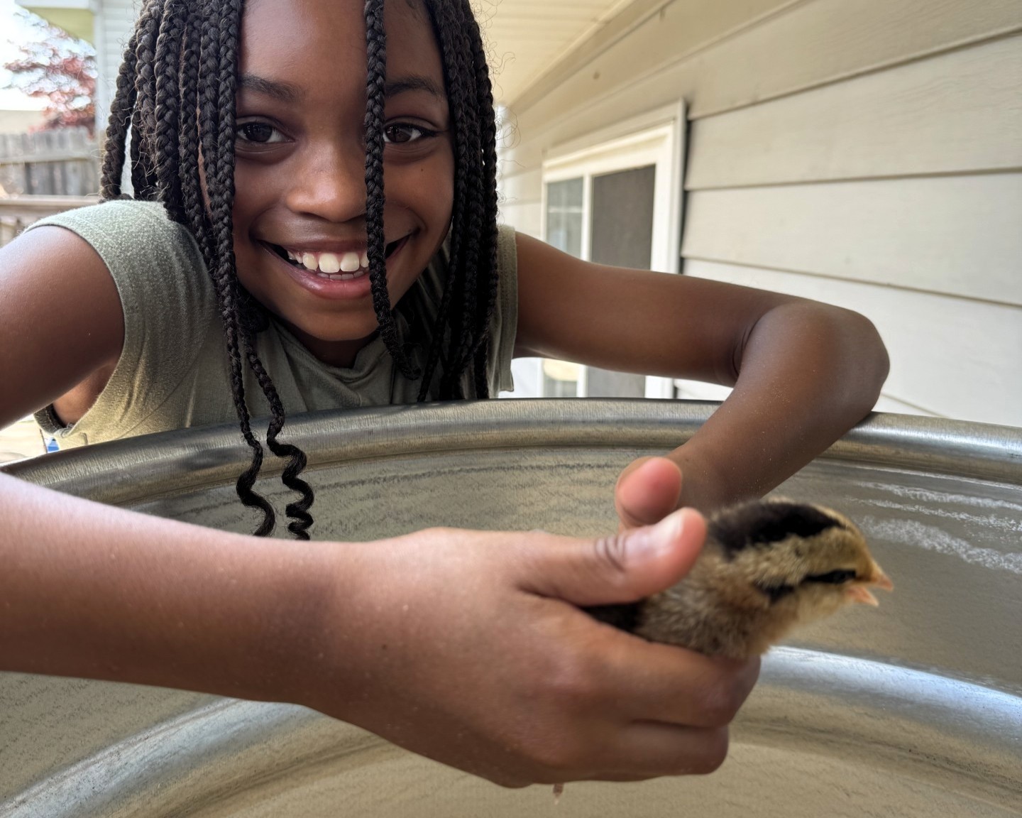 Child holding a baby chick at the MI-IMPACT Cluck Cluck Coop program